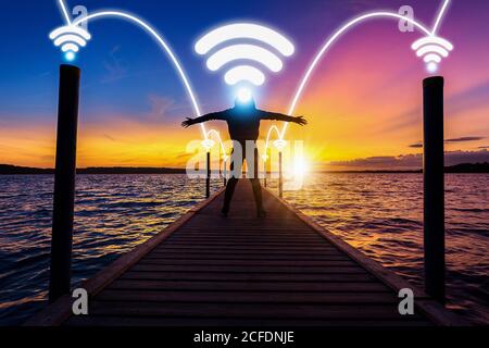 happy and relax woman, female, on wood bridge over sea with phone signal technology with network connection concept for happy in with nature and relax Stock Photo