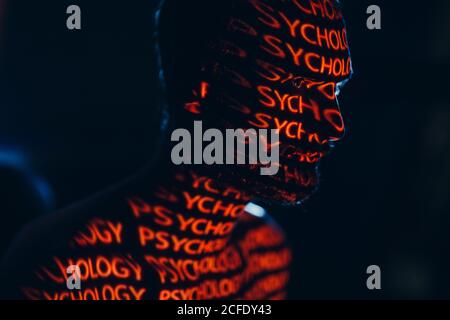 Young adult man with word Psychology on his face in the dark. Stock Photo