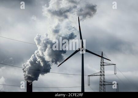 Wind turbine, electricity pylon and smoking chimney at the Uniper hard coal power station Scholven, Gelsenkirchen, Ruhr area, North Rhine-Westphalia, Stock Photo