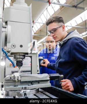 Remscheid, North Rhine-Westphalia, Germany - Apprentices in metal professions, here with trainers on a machine tool, vocational training center of Stock Photo