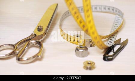 Tailor tools isolated on wooden background. Scissors, needle, Tailoring Meter, hand Stock Photo