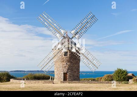A traditional windmill on the Breton coast not far from the port city of Paimpol. From there you can see the island of Brehat. Stock Photo