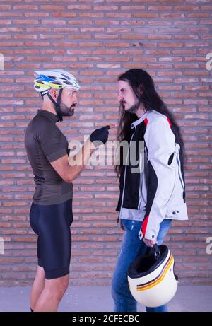 A cyclist and a biker looking at each other and arguing Stock Photo