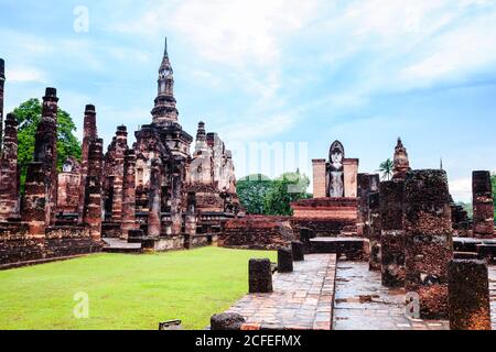 Sukhothai style chedi and standing buddha image in Sukhothai Historical Park, Sukhothai Province, Thailand. Stock Photo