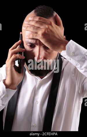 Anxious hispanic young man talking to the phone receiving bad news Stock Photo