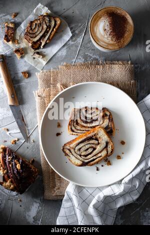 Plate with pieces of tasty homemade roll pie with chocolate Stock Photo