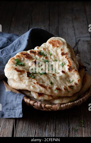 Plate with delicious naan bread and cloth napkin placed on weathered lumber table Stock Photo