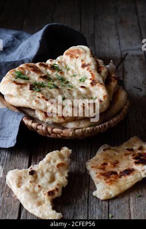 Plate with delicious naan bread and cloth napkin placed on weathered lumber table Stock Photo