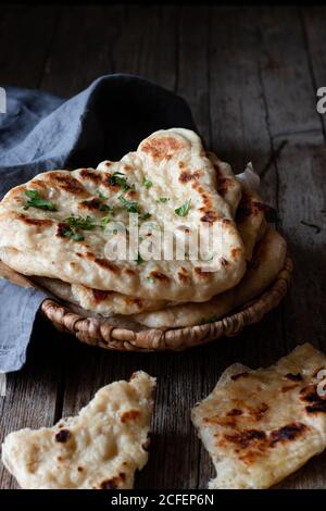 Plate with delicious naan bread and cloth napkin placed on weathered lumber table Stock Photo
