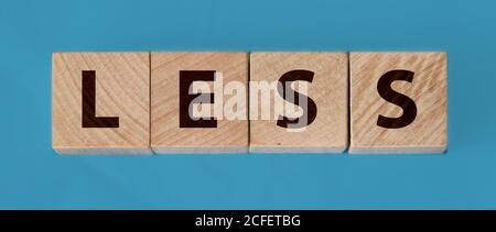 Less word on wooden cubic blocks with letters. cut costs business concept Stock Photo