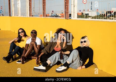 Serious youthful multiracial female friends resting on stadium Stock Photo