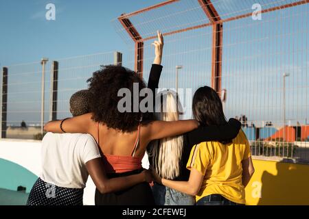 Cheerful young diverse female friends taking selfie on smartphone in street Stock Photo