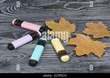 Colored markers. Nearby are dried maple leaves. On brushed pine boards painted black and white. Stock Photo