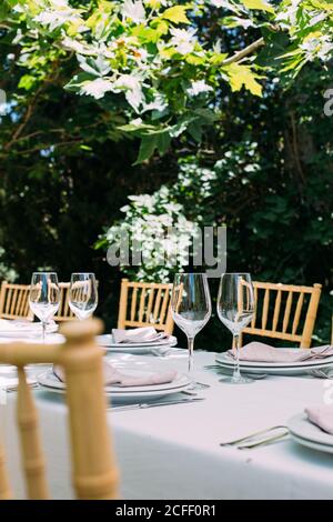 Outdoor rustic celebration table with cutlery and glasses Stock Photo