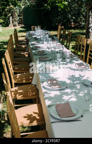 Outdoor rustic celebration table with cutlery and glasses Stock Photo