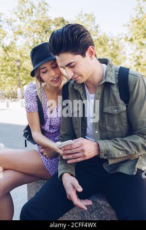 Young handsome man phone with girlfriend using phone sitting in beautiful garden Stock Photo