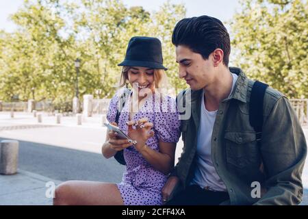 Young handsome man phone with girlfriend using phone sitting in beautiful garden Stock Photo