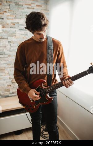 man playing guitar at home Stock Photo