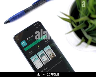 Lod, Israel - July 8, 2020: Modern minimalist office workspace with black mobile smartphone with Mi Home app play store page on white background. Top Stock Photo