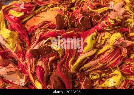 Closeup of vivid red and yellow thick wavy lines poured randomly on surface and spraying small drops Stock Photo