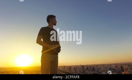 Silhouette of a photographer taking pictures on top of the building at sunset Stock Photo