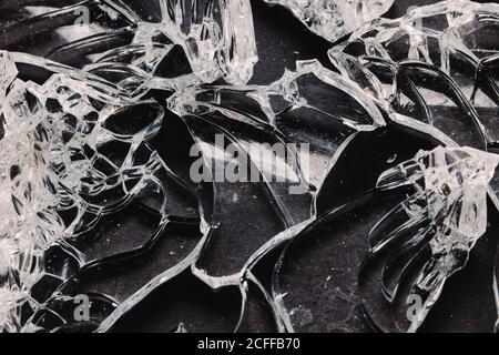 abstract background with shiny pieces of broken transparent glass on dark surface as concept of fake crystals and gems Stock Photo