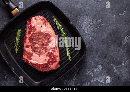Fresh raw beef steak on frying grill pan, top view. Stock Photo