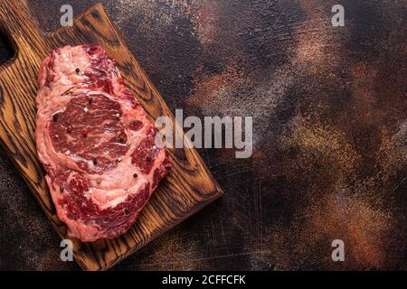Fresh raw beef steak on a cutting wooden board, top view. Stock Photo