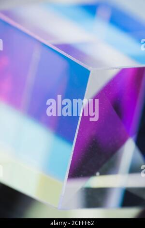 abstract background with closeup shot of glossy crystal block with multicolored gradient reflection on blurred mirror surface Stock Photo