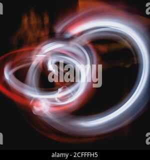 abstract background with diffused tracks of bright red and white rays against dark blurred surface Stock Photo