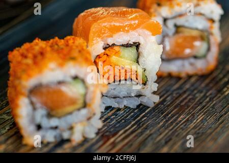 a trio of different california sushi rolls on a plate with a selection of fillings close up Stock Photo