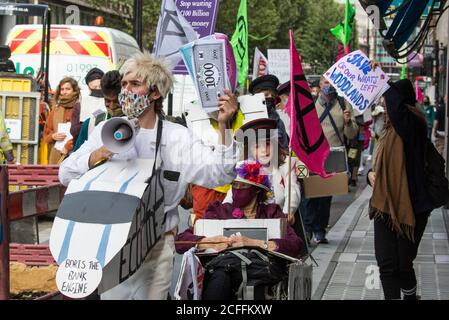 London, UK. 4th September, 2020. Activists from HS2 Rebellion, an umbrella campaign group comprising longstanding campaigners against the HS2 high-speed rail link as well as Extinction Rebellion activists, march with the handmade Boris the Bank Engine to a protest rally in Parliament Square. The rally, and a later protest action at the Department of Transport during which activists glued themselves to the doors and pavement outside and sprayed fake blood around the entrance, coincided with an announcement by HS2 Ltd that construction of the controversial £106bn high-speed rail link will now co Stock Photo