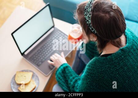 Top view of a Woman having breakfast while working at home on her laptop Stock Photo