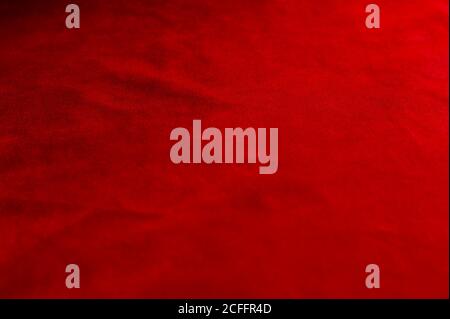 Dark red matte background of suede fabric, closeup. Velvet texture of seamless wine leather. Felt material macro. Stock Photo