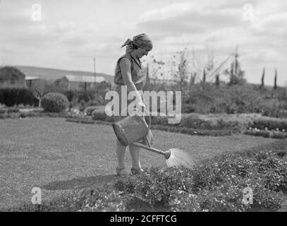 Nahalal. Girls' Agricultural Training School. Watering flower garden. Girl with water can ca. 1920 Stock Photo