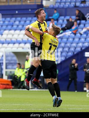 Harrogate Town's Lloyd Kerry (right) celebrates scoring his side's first goal of the game with team-mate Josh Falkingham during the Carabao Cup first round match at Prenton Park, Birkenhead. Stock Photo