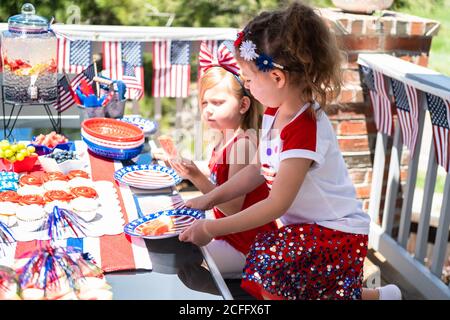 Little girls are playing at the July 4th party on the back patio. Stock Photo