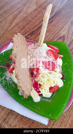 Spaghetti ice with strawberries and waffles, served in a traditional italian restaurant Stock Photo