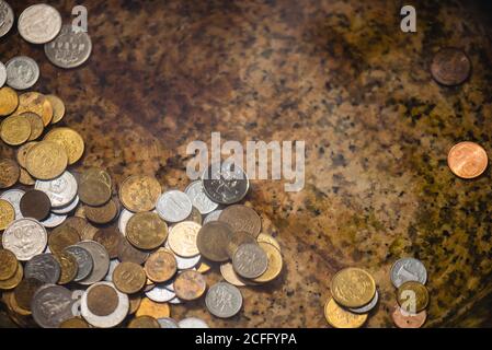 From above of shiny various coins on stone surface of fountain under water Stock Photo