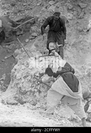 Middle East History - Tel Deweir (Lachish). Men clearing burnt line debris. Iron lance heads arrowheads & fragments of scale armour found in this area due to attack 588 B.C. Stock Photo