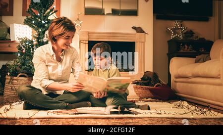 Mother reading book with son on Christmas eve Stock Photo