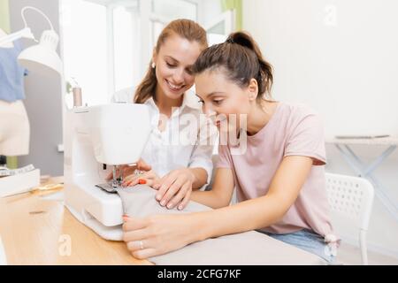 Student girl with teacher in dressmaking class, woman sewing lessons Stock Photo