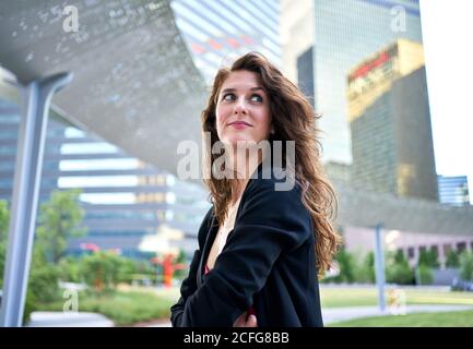 Determined smiling businessWoman against skyscrapers in downtown Stock Photo