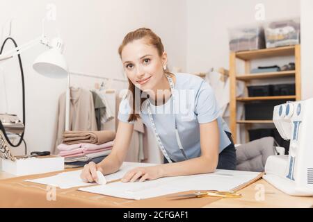 Female designer dressmaker working on sewing machine in studio Stock Photo