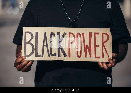 anonymous man protesting at a rally for racial equality holding a 'Black Power' poster. Black Lives Matter. Stock Photo
