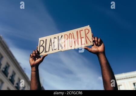 unrecognizable man protesting at a rally for racial equality holding a 'Black Power' poster. Black Lives Matter. Stock Photo