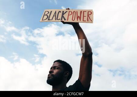 man protesting at a rally for racial equality holding a 'Black Power' poster. Black Lives Matter. Stock Photo