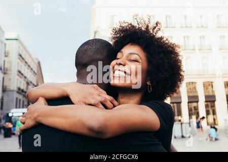 Happy african american couple hugging on the street in a summer day Stock Photo