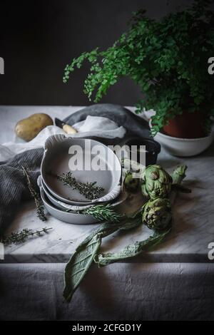 Different herbs in bowls placed on rustic table Stock Photo