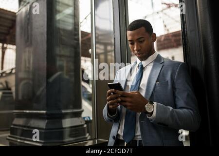 Trendy black businessman using phone Stock Photo